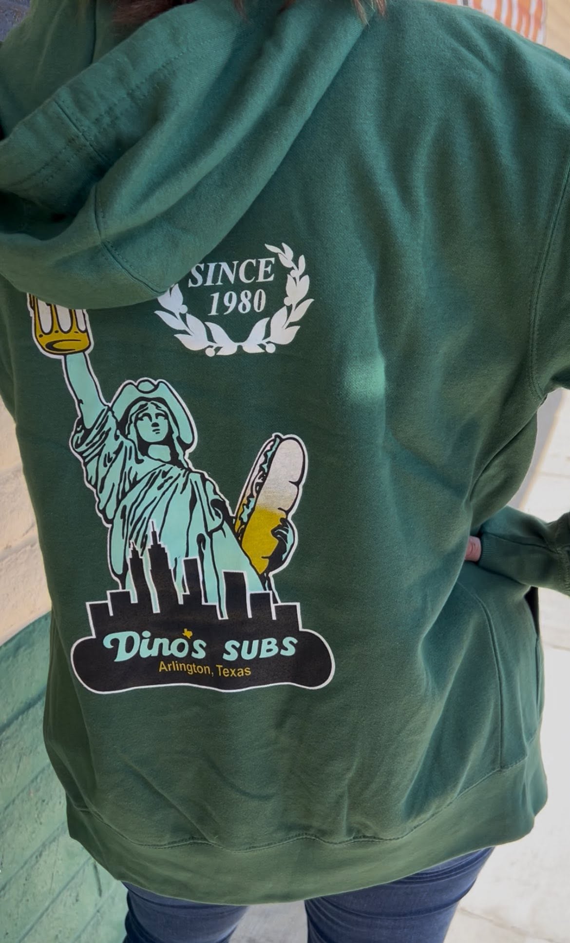 Green Dino's Subs hoodie with the skyline graphic